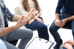 People at group therapy session discussing coronavirus addiction and work