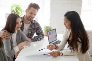 Couple sits with representative to review insurance benefits and adopt a new insurance plan.