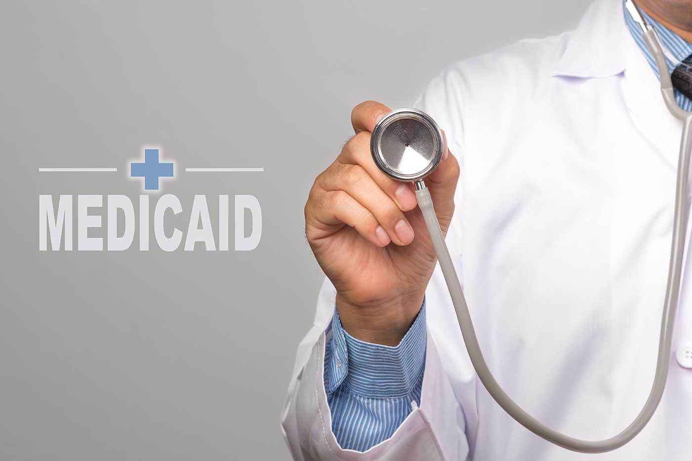 MEDICAID y el médico sosteniendo un estetoscopio