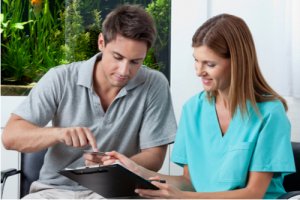 Man paying bill for treatment to female staff