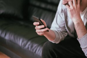 Man looking at an addiction recovery app on his cell.