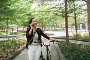 woman on phone with bike returning to work after rehab